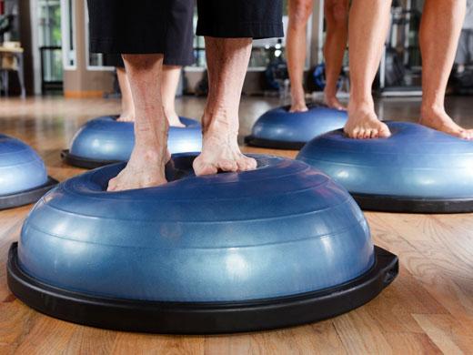 several people's feet balancing on exercise balls